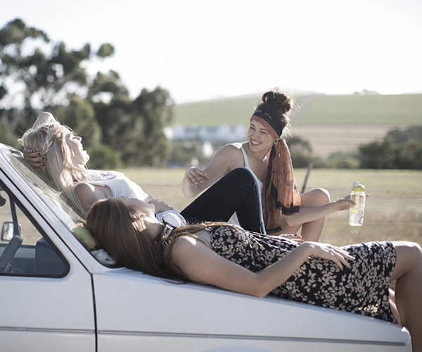 South Africa, Friends on a road trip resting on car bonnet